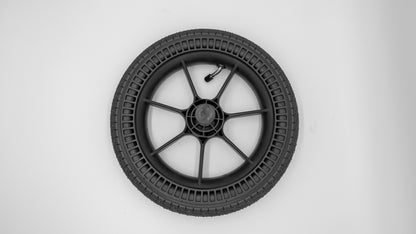 Schwarzes Hinterrad für Moon Kinderwagen, mit sichtbarem Luftventil und runder Reifenform, aufgenommen von oben.