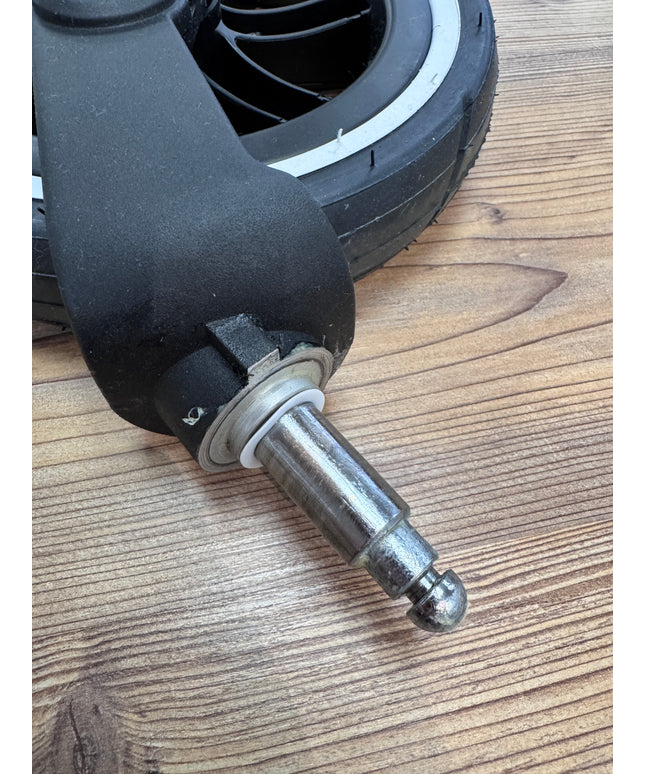 Detailaufnahme eines Vorderrades eines ABC Design Kinderwagens, auf dem die Abstandsringe montiert sind. Der schwarze Reifen mit weißer Linie und die Metallachse sind gut sichtbar.